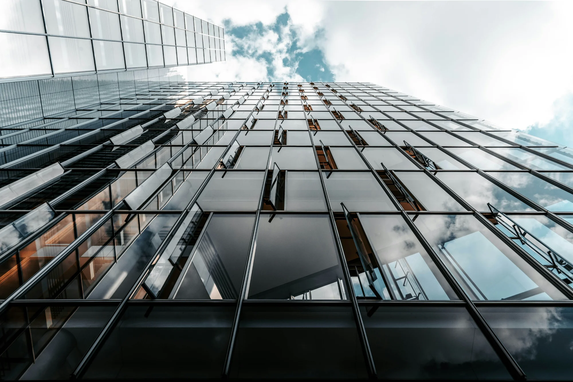 Modern glass building facade with cloud reflections